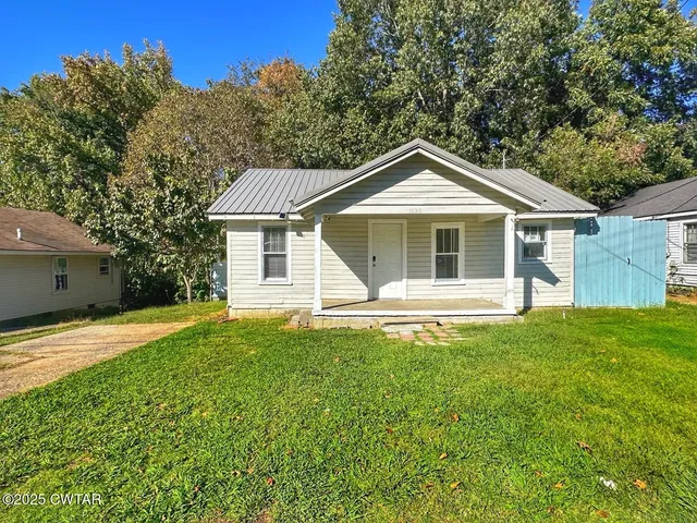 a front view of a house with yard and green space