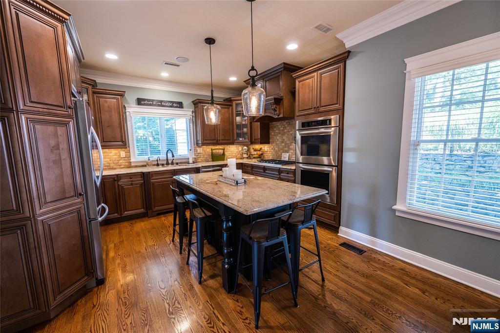 44 Forest Terrace Wayne, NJ 07470 - Photo 14 of 32 a kitchen with stainless steel appliances granite countertop a refrigerator a sink dishwasher a stove and a dining table with wooden floor