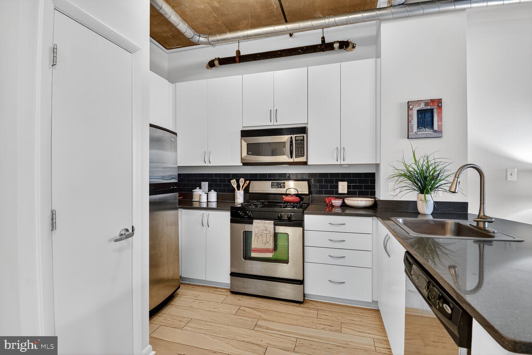 1300 N Street Northwest, Unit 214 Washington, DC 20005 - Photo 7 of 41 a kitchen with stainless steel appliances white cabinets and a stove top oven