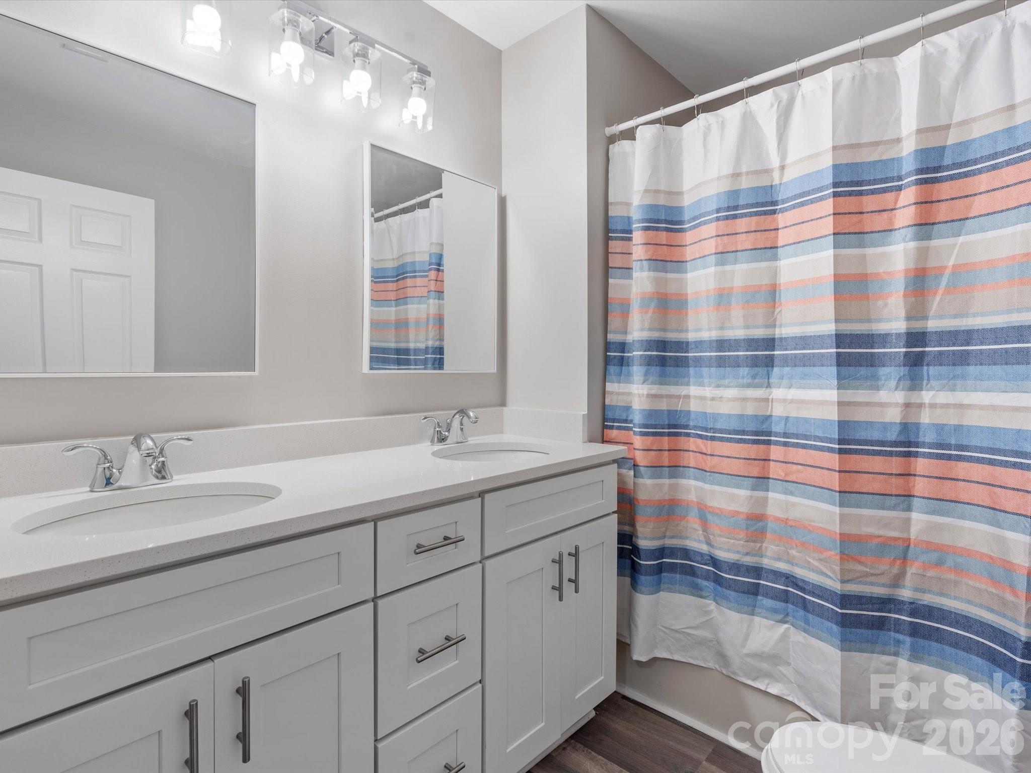 105 South York Street Lancaster, SC 29720 - Photo 26 of 28 a bathroom with a sink a mirror a vanity and shower