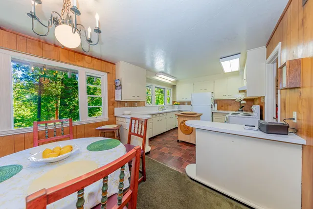 a kitchen with a sink a stove a refrigerator and white cabinets