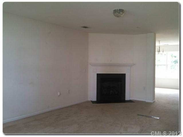 2216 Gooseberry Road Charlotte, NC 28208 - Photo 4 of 12 a view of an empty room with a fireplace and a window
