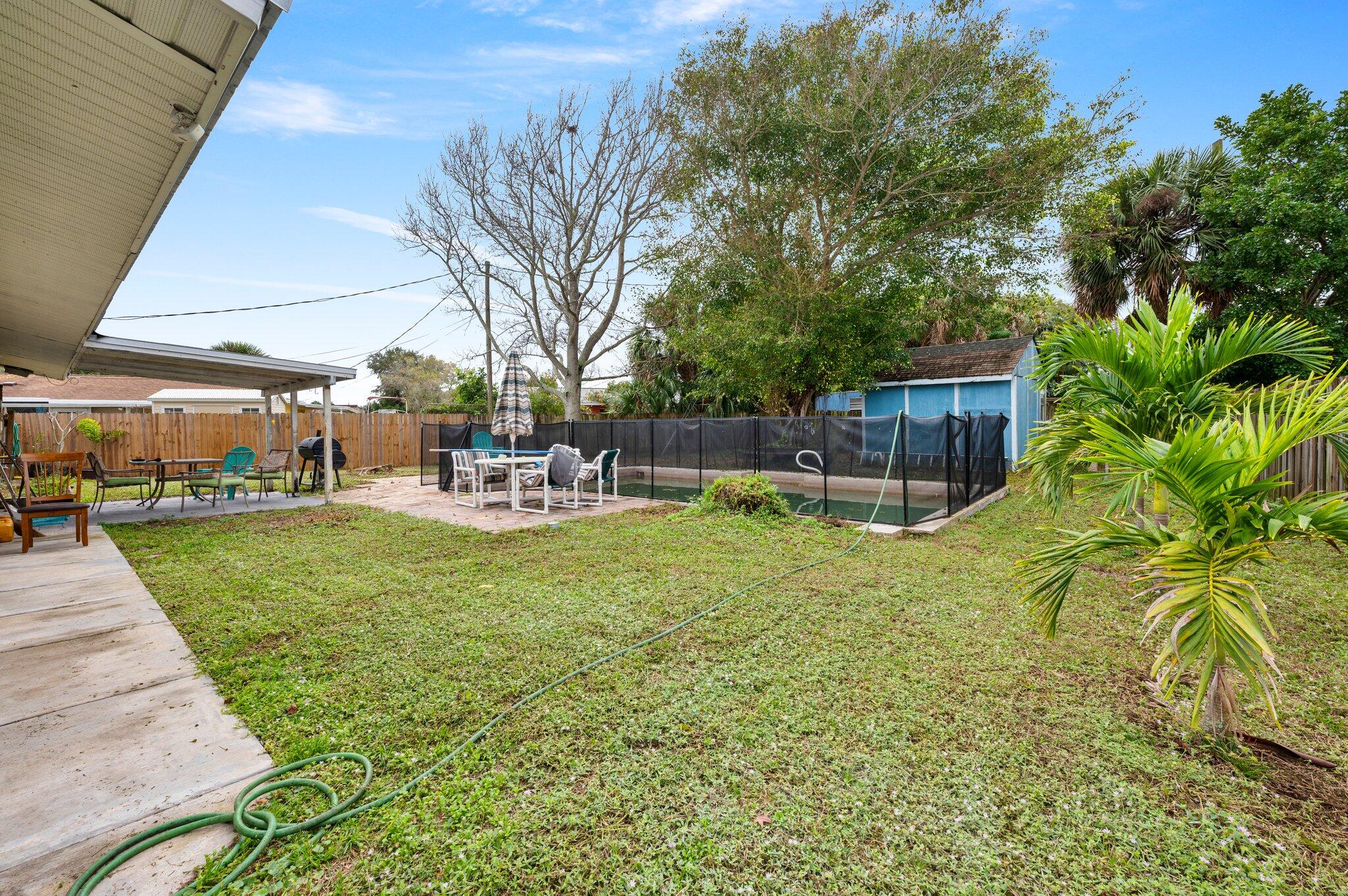 822 Onyx Drive Northeast Palm Bay, FL 32905 - Photo 2 of 21 a view of a swimming pool with a table and chairs
