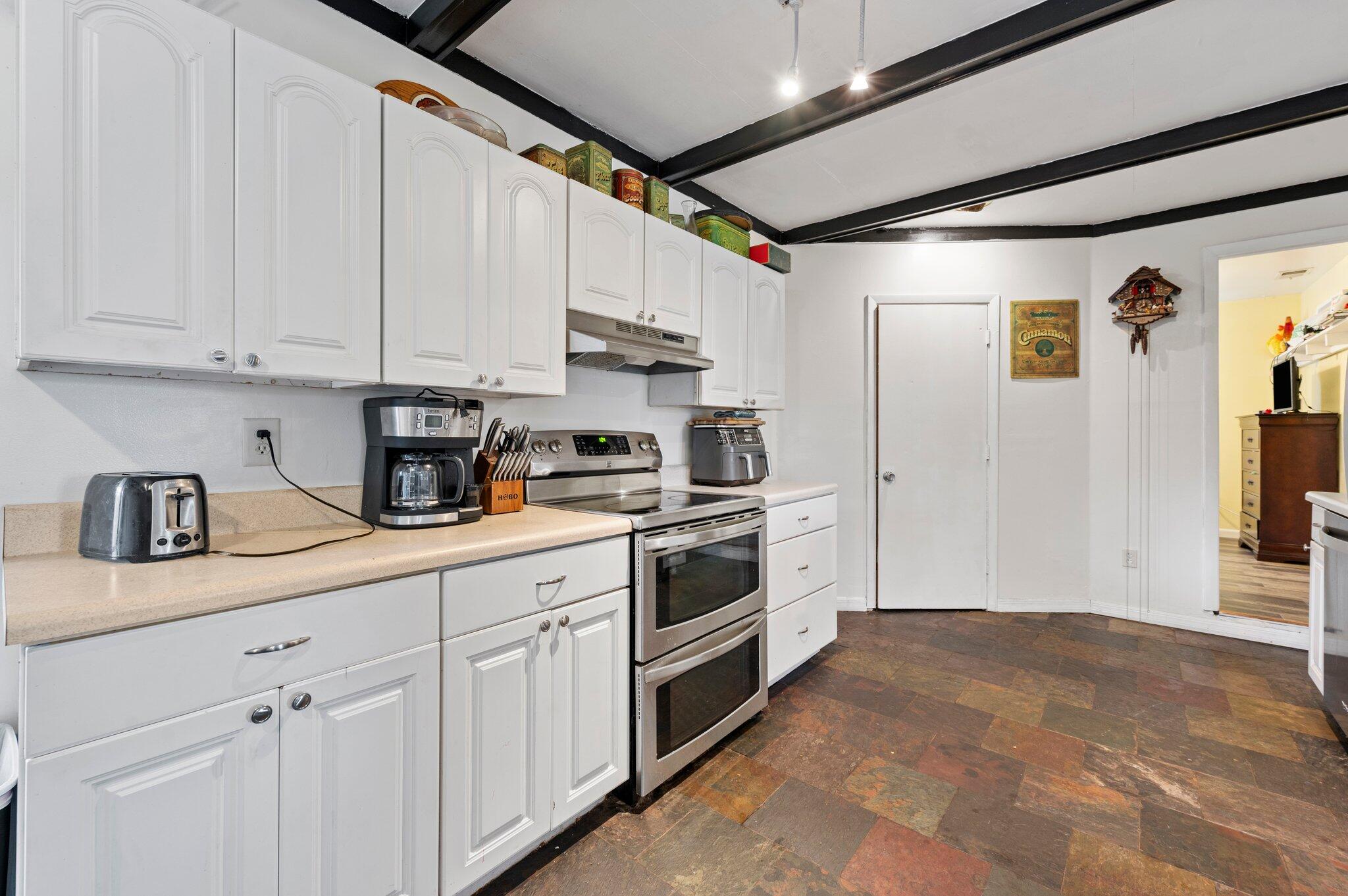 822 Onyx Drive Northeast Palm Bay, FL 32905 - Photo 8 of 21 a kitchen with white cabinets and white appliances