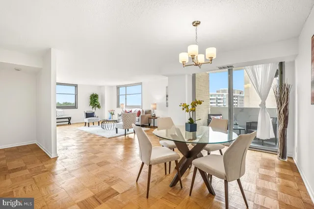 a view of a dining room with furniture a chandelier and wooden floor