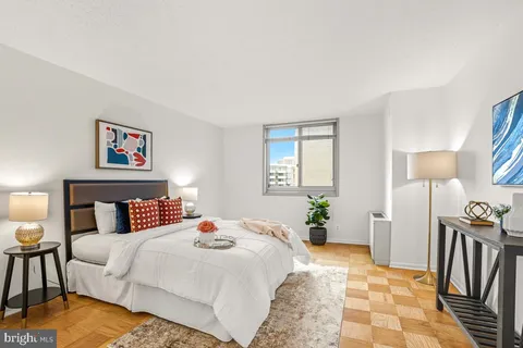 a bedroom with a bed a mirror and lamp