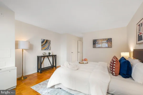 a bedroom with a bed a table and painting on the wall