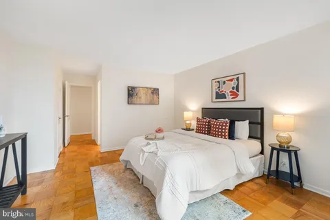 a bedroom with a bed and a lamp on dresser