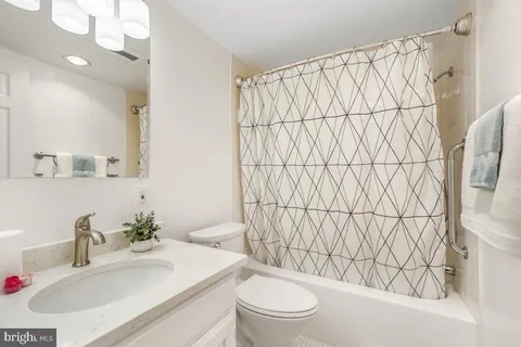 a bathroom with a sink a toilet and shower curtain
