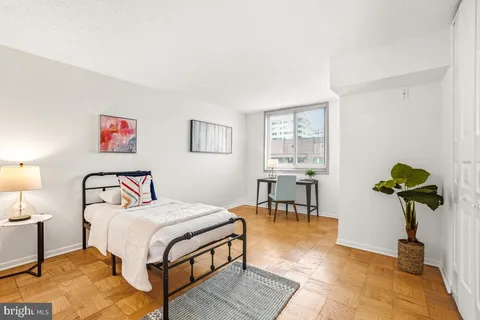 a bedroom with a bed table and a potted plant