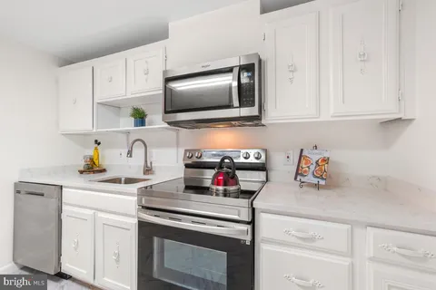 a kitchen with stainless steel appliances granite countertop a sink and a stove