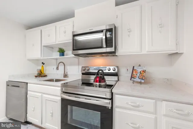 a kitchen with stainless steel appliances granite countertop a sink and a stove