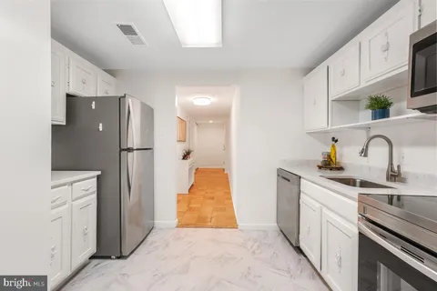 a kitchen with stainless steel appliances a refrigerator sink and cabinets