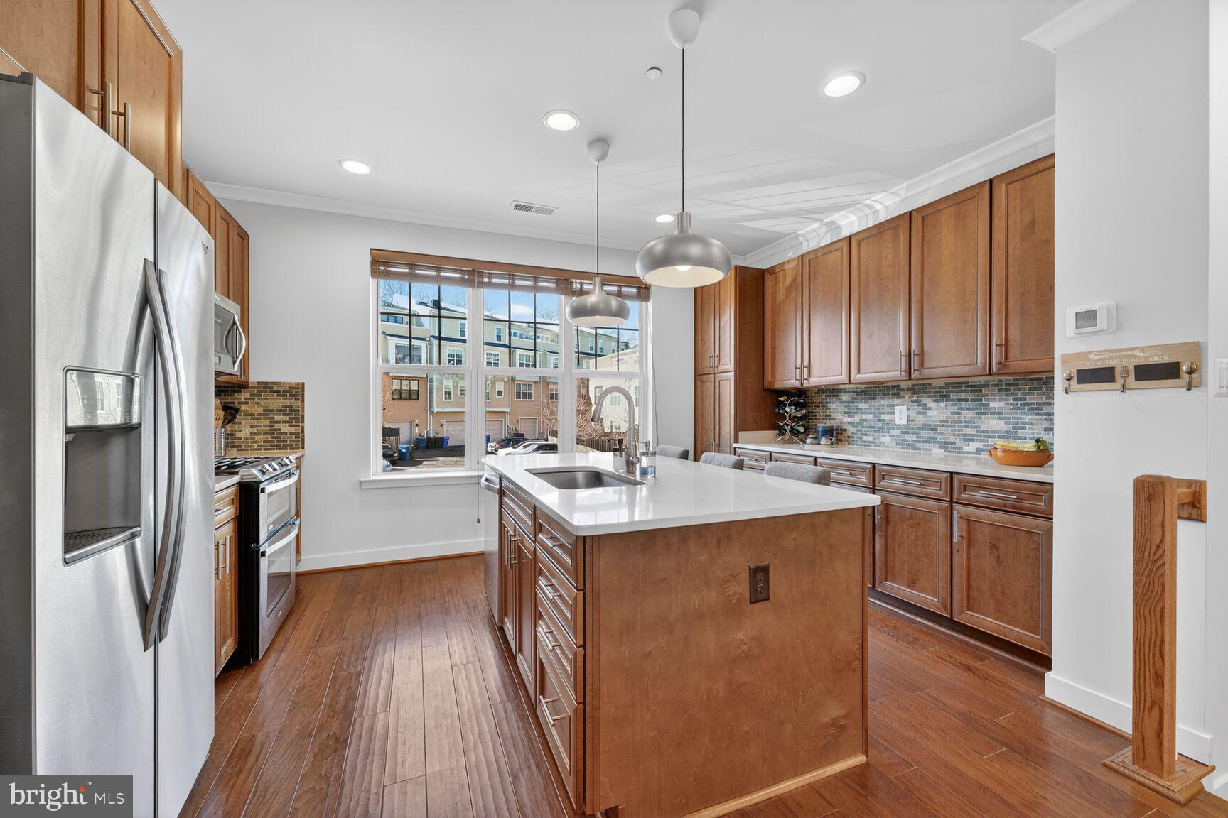 3328 7th Street Northeast Washington, DC 20017 - Photo 6 of 30 a kitchen with stainless steel appliances granite countertop a refrigerator a sink dishwasher a stove and white countertops with wooden floor