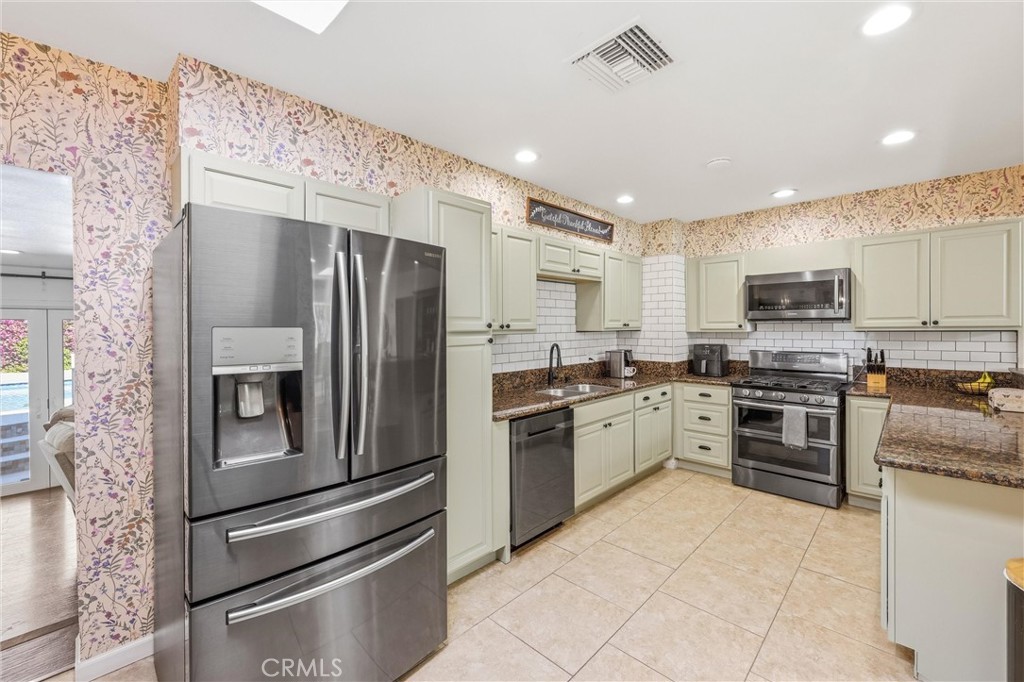 11 E Crescent Redlands, CA 92373 - Photo 12 of 35 a kitchen with granite countertop stainless steel appliances and wooden cabinets