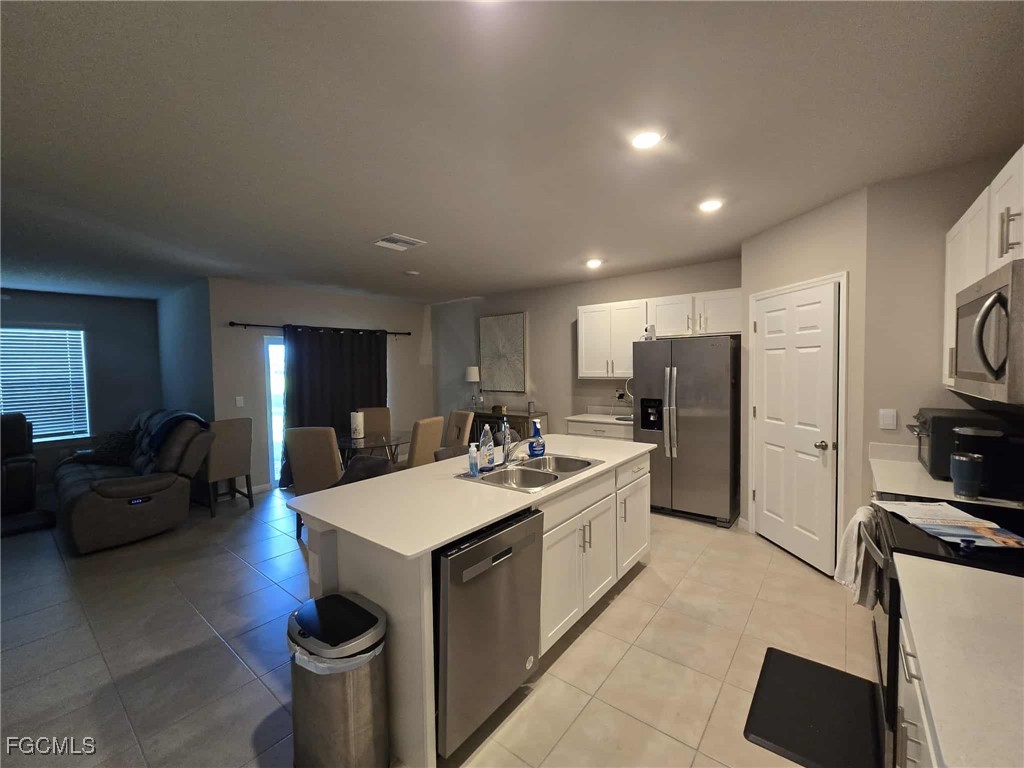 Undisclosed Address Punta Gorda, FL 33955 - Photo 3 of 17 a large kitchen with stainless steel appliances a stove a sink dishwasher a refrigerator and white cabinets with wooden floor