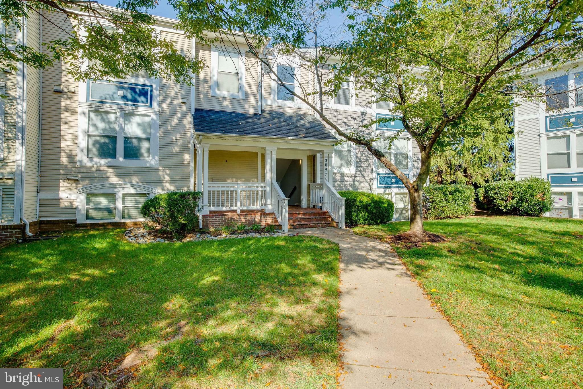 20575 Snowshoe Square, Unit 302 Ashburn, VA 20147 - Photo 1 of 32 a front view of house with yard and green space
