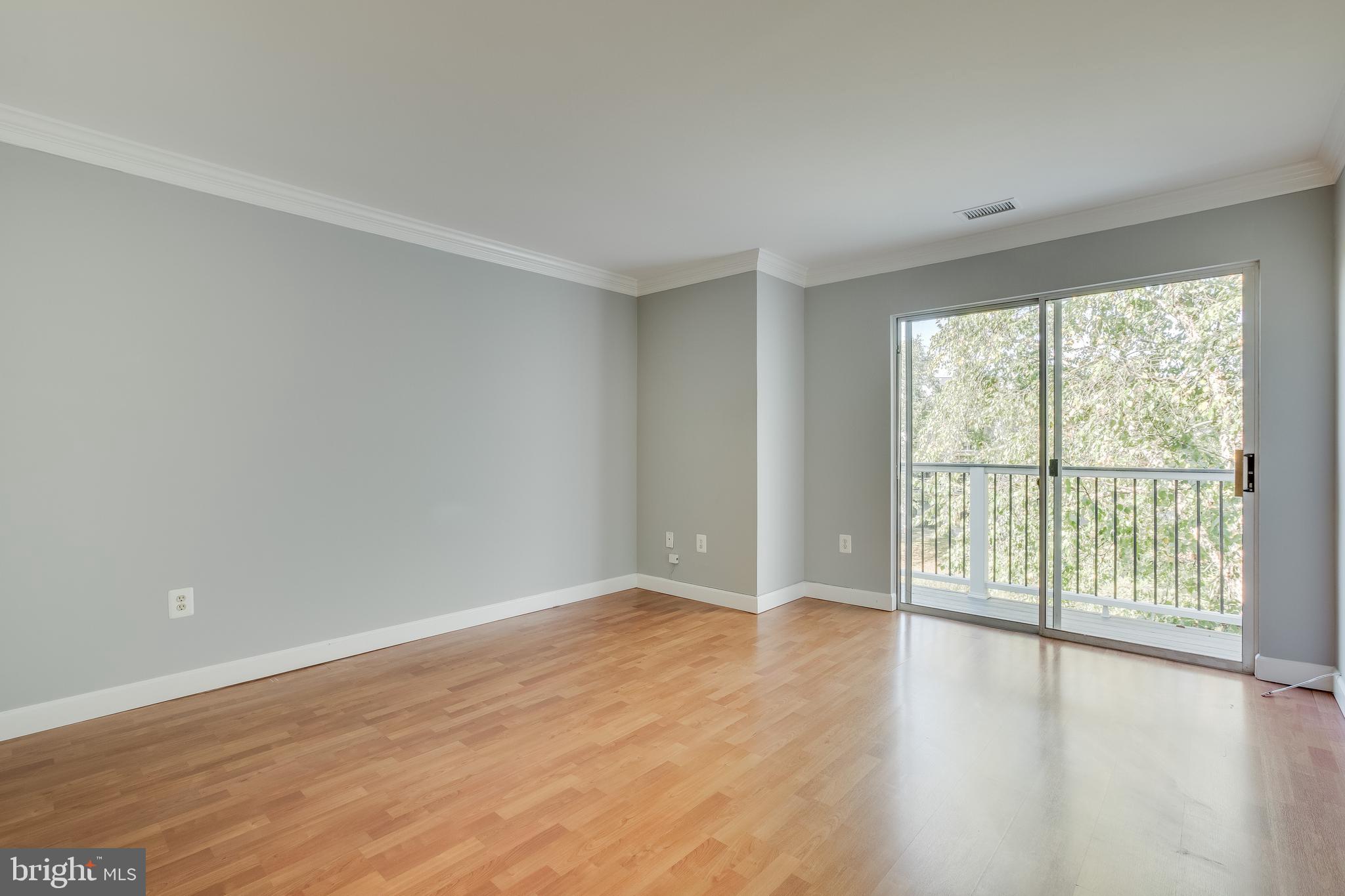 20575 Snowshoe Square, Unit 302 Ashburn, VA 20147 - Photo 15 of 32 a view of an empty room with wooden floor and a window