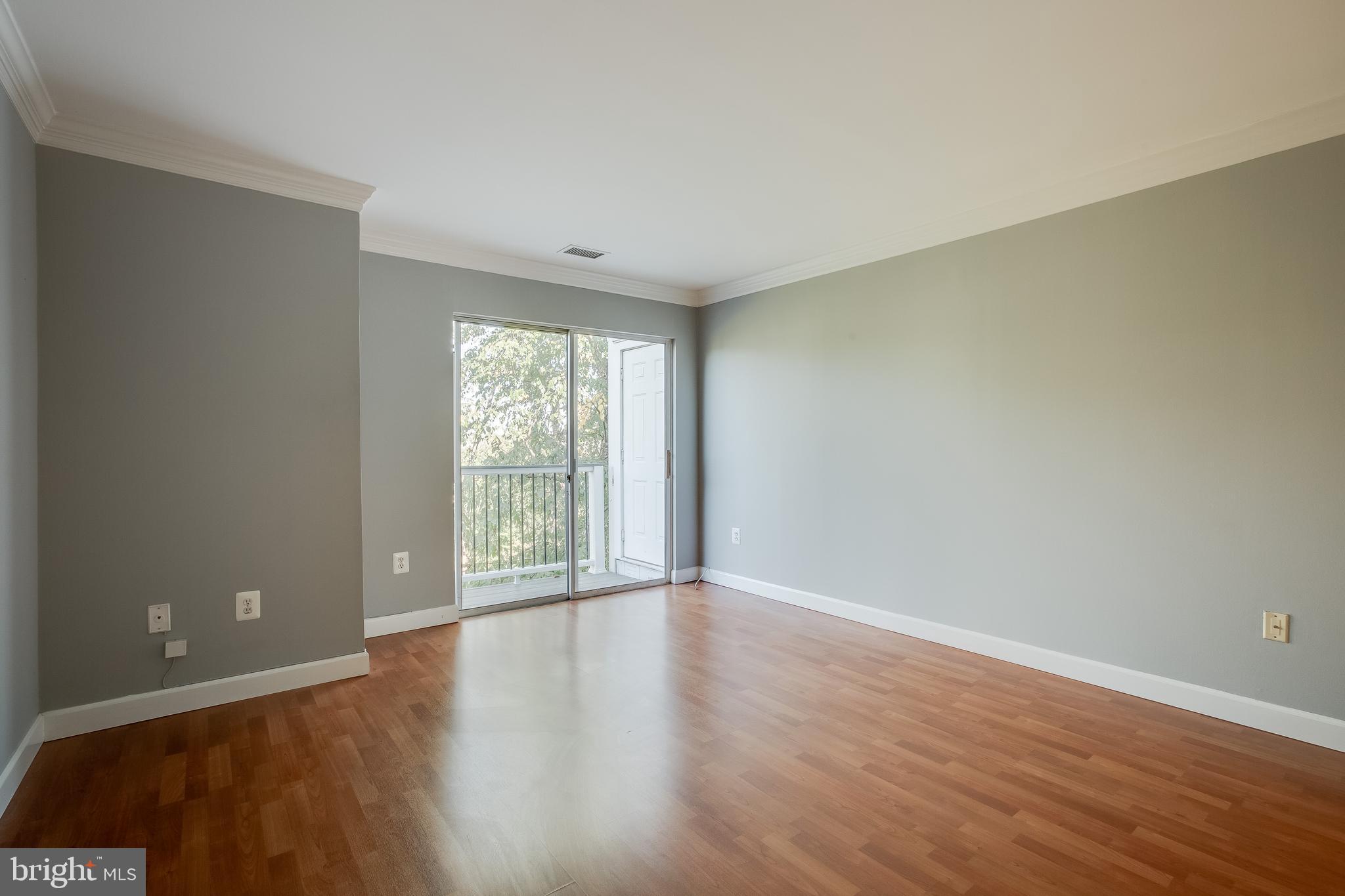 20575 Snowshoe Square, Unit 302 Ashburn, VA 20147 - Photo 16 of 32 a view of an empty room with wooden floor and a window
