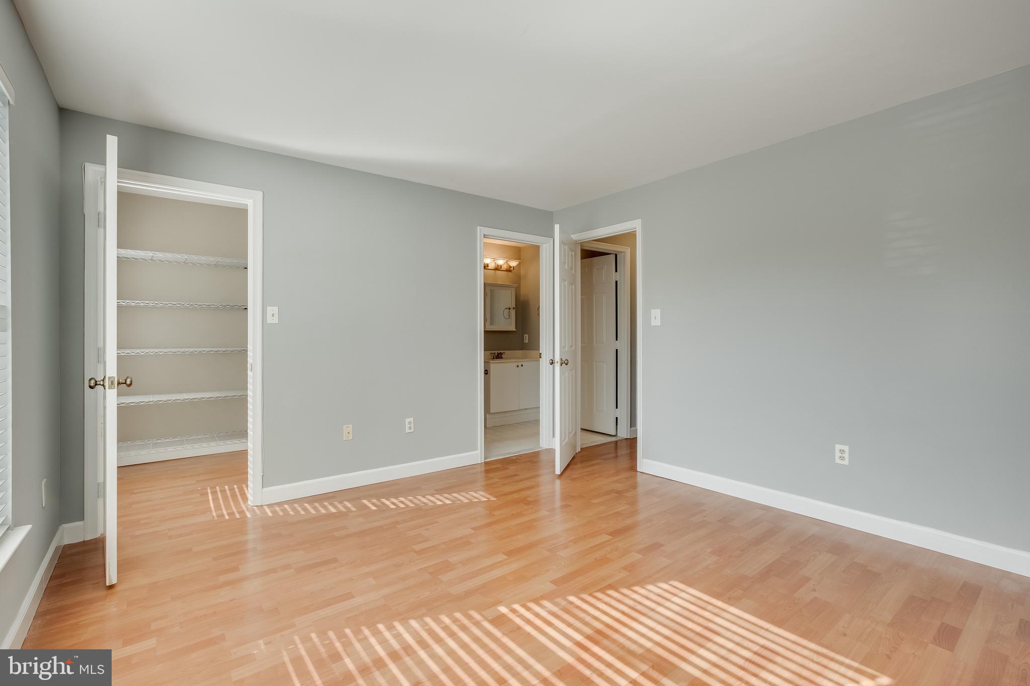 20575 Snowshoe Square, Unit 302 Ashburn, VA 20147 - Photo 18 of 32 a view of an empty room with wooden floor and closet
