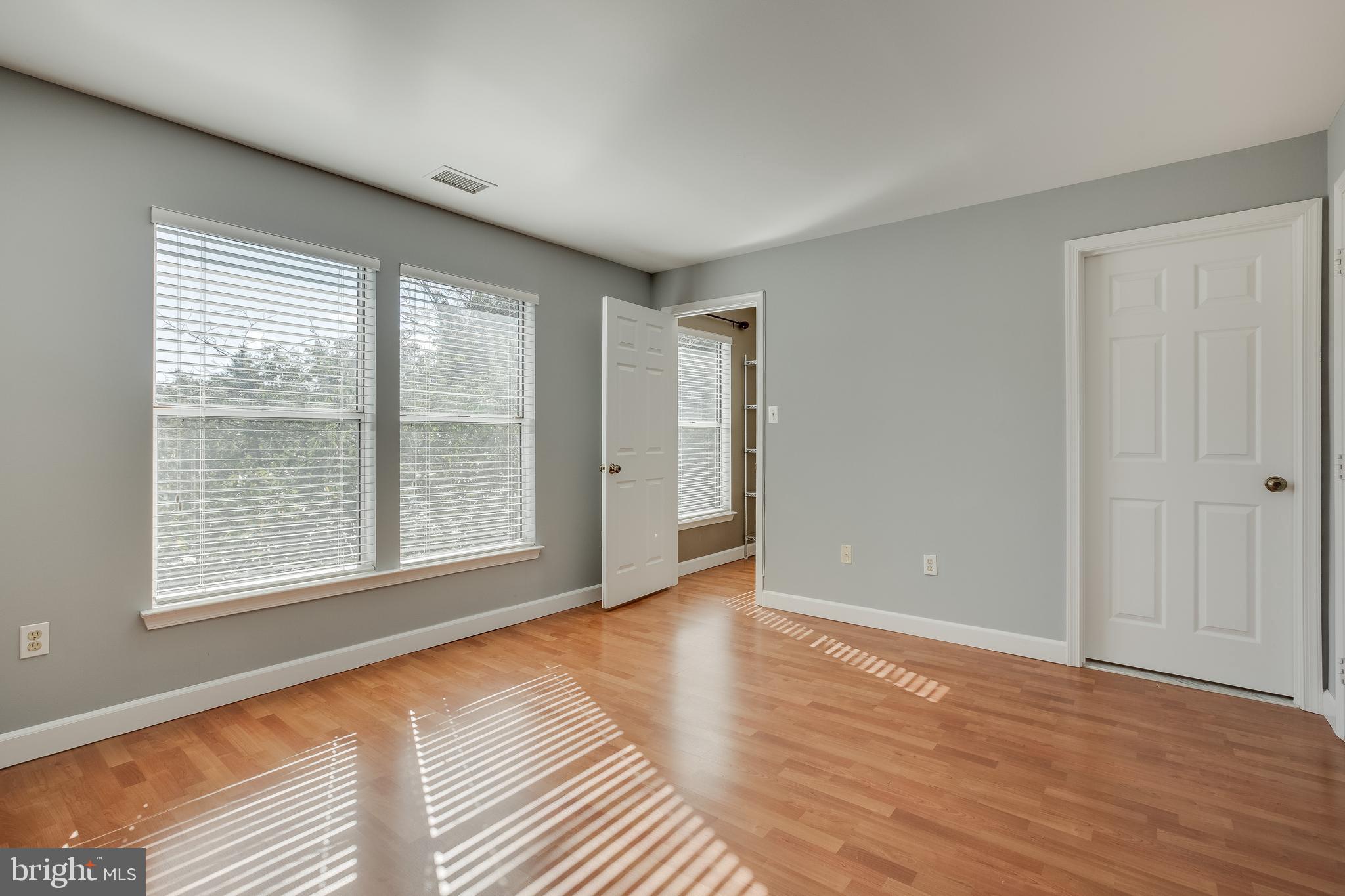 20575 Snowshoe Square, Unit 302 Ashburn, VA 20147 - Photo 19 of 32 a view of an empty room with wooden floor and a window