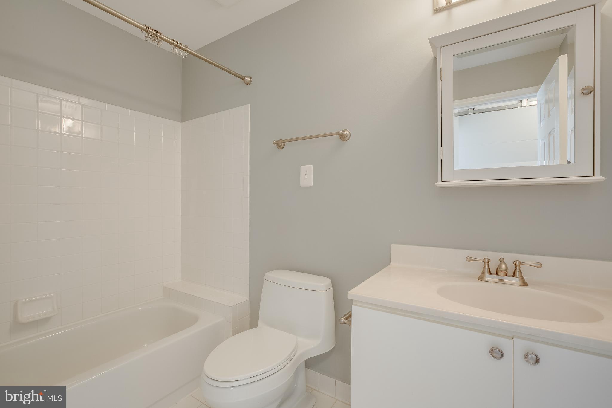20575 Snowshoe Square, Unit 302 Ashburn, VA 20147 - Photo 21 of 32 a bathroom with a sink toilet and shower