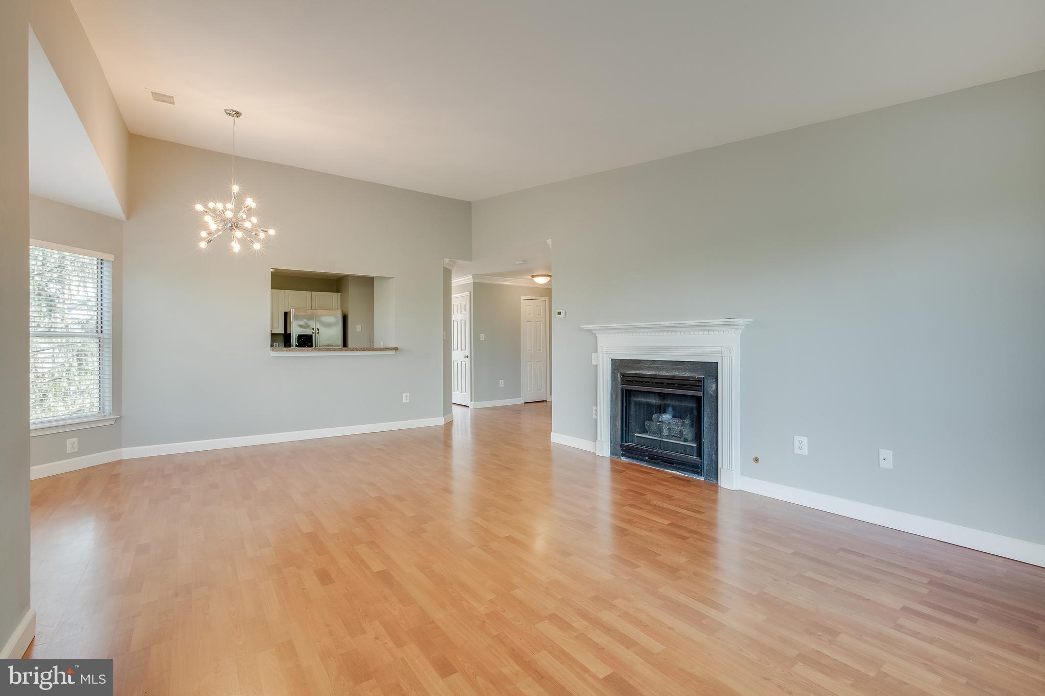 20575 Snowshoe Square, Unit 302 Ashburn, VA 20147 - Photo 23 of 32 an empty room with windows and fireplace