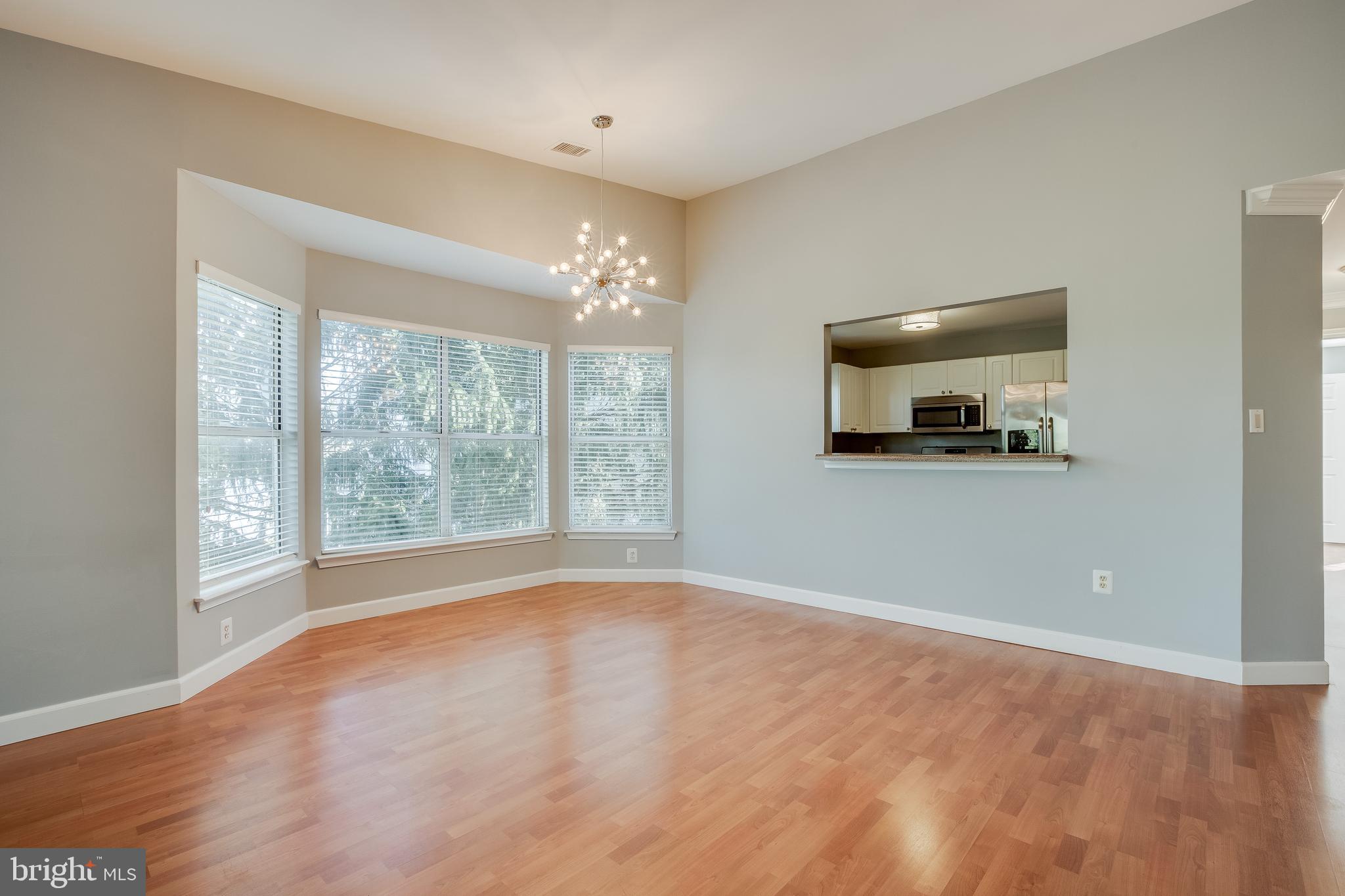 20575 Snowshoe Square, Unit 302 Ashburn, VA 20147 - Photo 24 of 32 a view of an empty room with a window and wooden floor