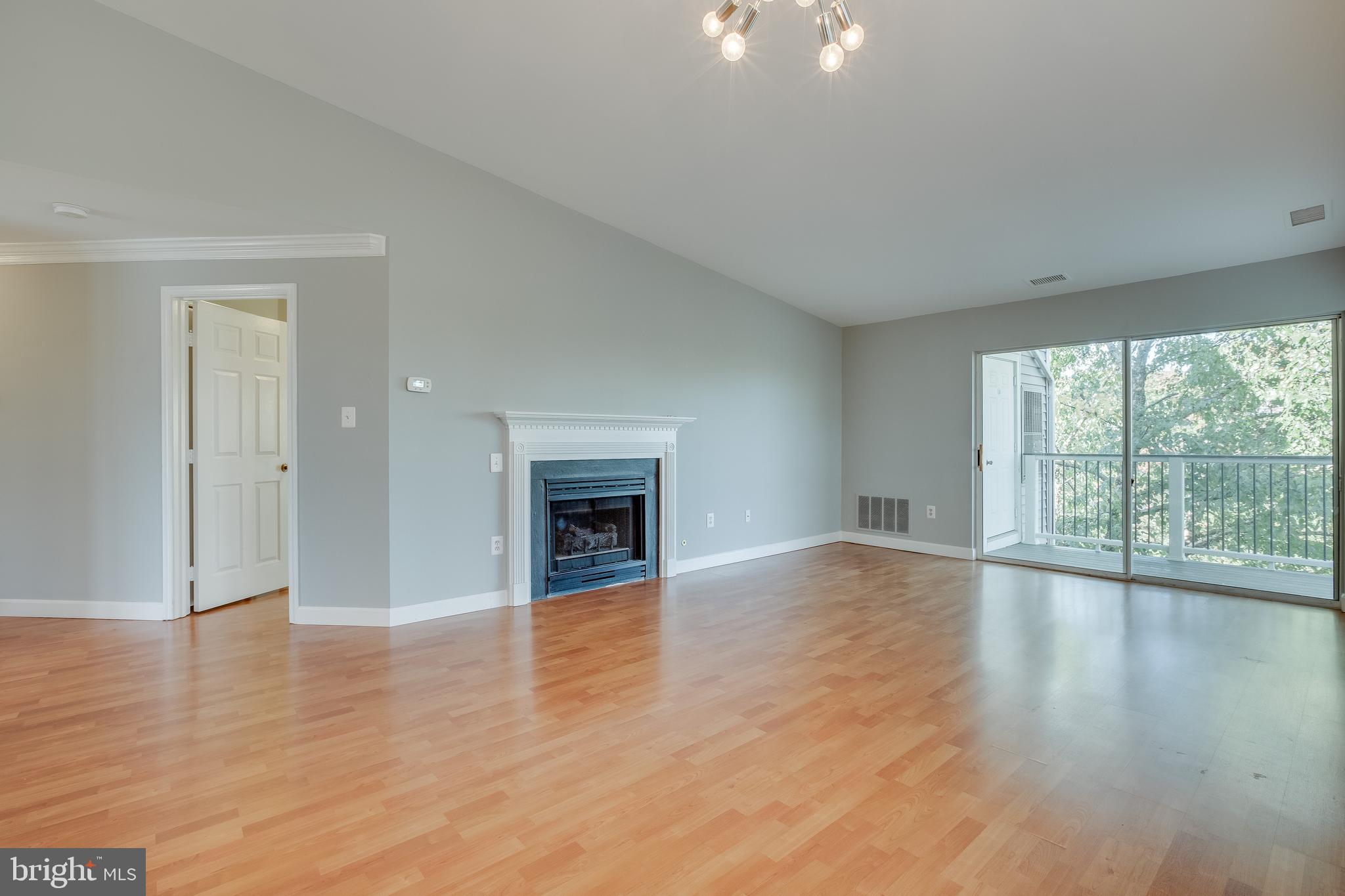 20575 Snowshoe Square, Unit 302 Ashburn, VA 20147 - Photo 5 of 32 a view of an empty room with wooden floor and a window