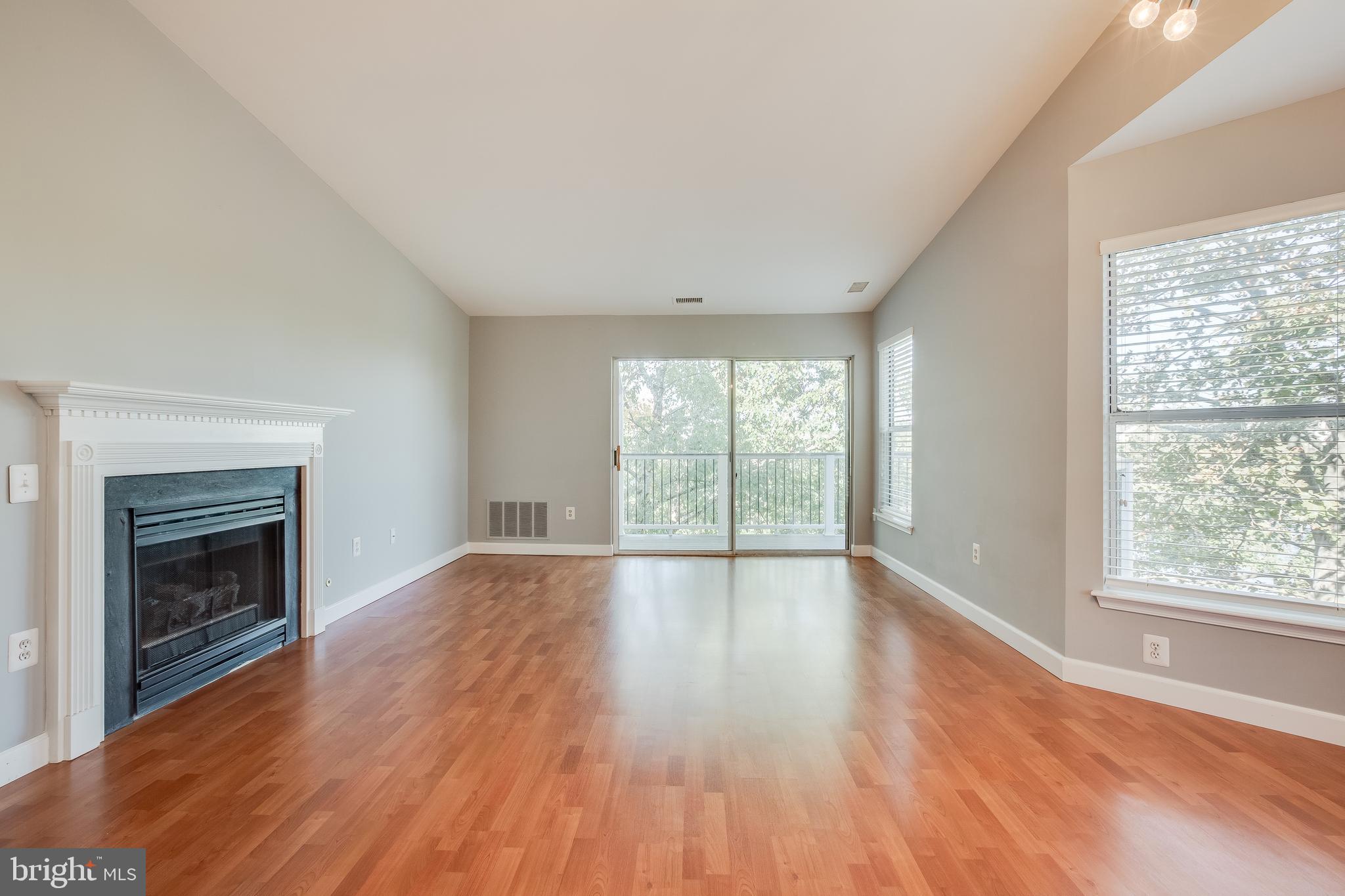 20575 Snowshoe Square, Unit 302 Ashburn, VA 20147 - Photo 6 of 32 wooden floor fireplace and natural light in room