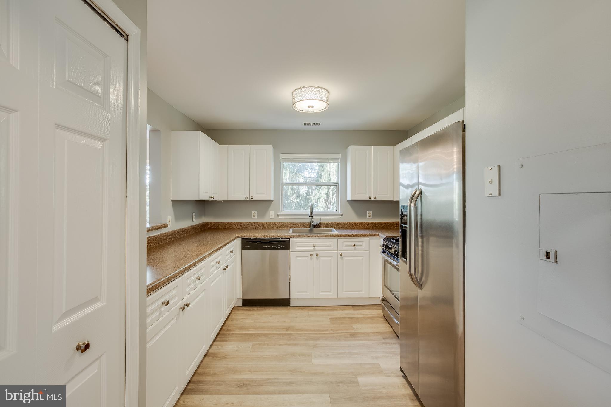 20575 Snowshoe Square, Unit 302 Ashburn, VA 20147 - Photo 7 of 32 a kitchen with granite countertop a refrigerator and a sink