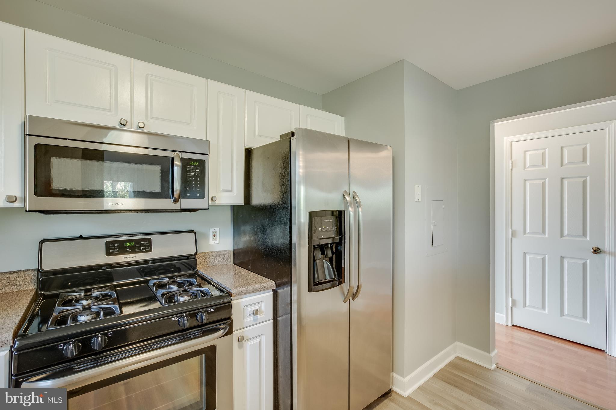 20575 Snowshoe Square, Unit 302 Ashburn, VA 20147 - Photo 8 of 32 a kitchen with stainless steel appliances granite countertop a refrigerator stove and microwave