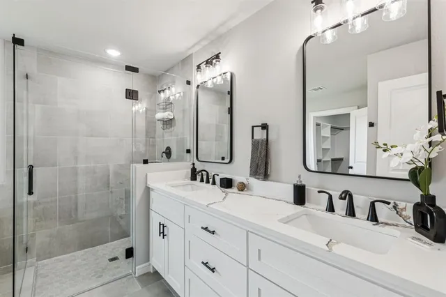 a bathroom with a double vanity sink mirror and shower