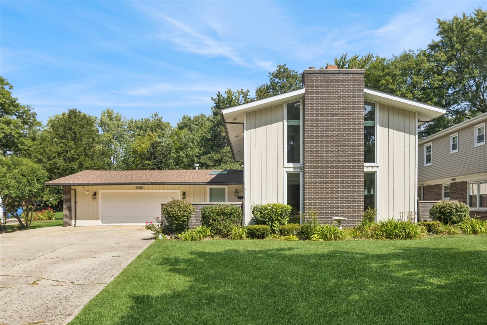 a front view of house with yard and trees