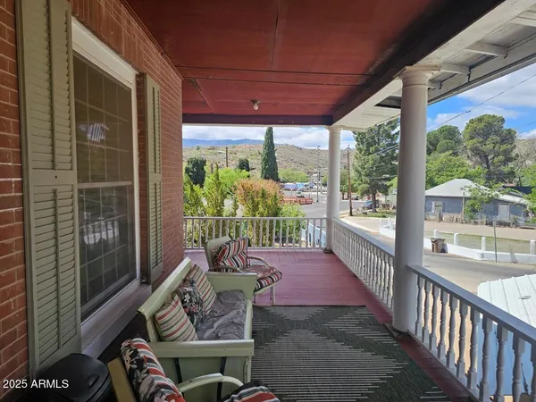 a view of a porch with furniture and floor to ceiling window