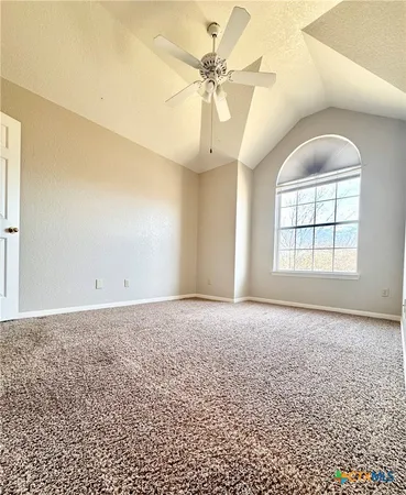 an empty room with windows and ceiling fan