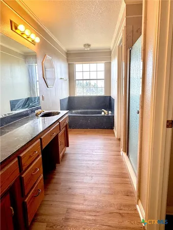 a view of a kitchen with kitchen island a sink wooden floor and a large window