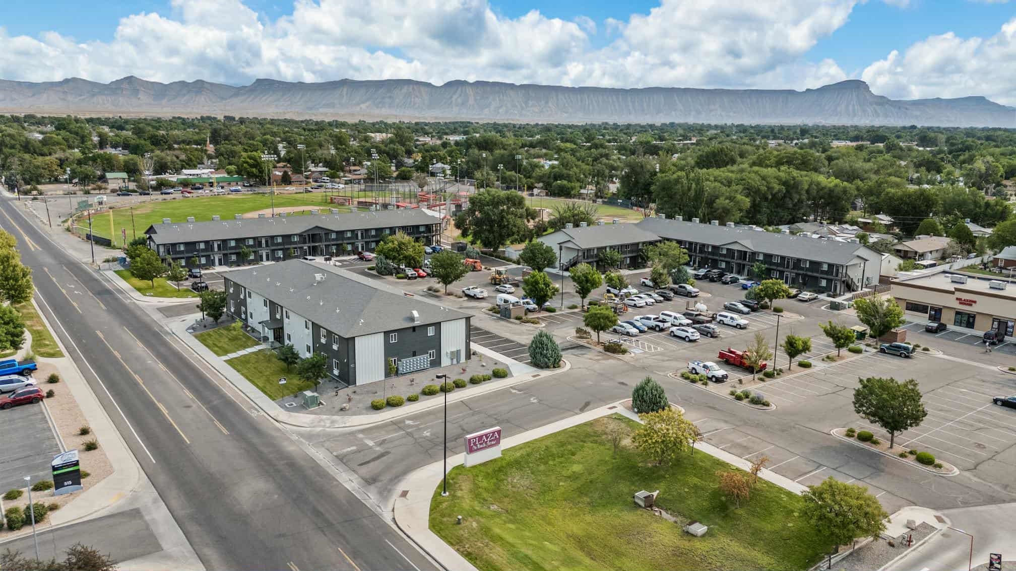 an aerial view of residential houses with outdoor space and ocean view
