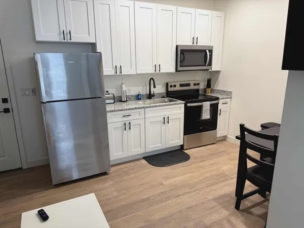 a kitchen with granite countertop a refrigerator stove and microwave