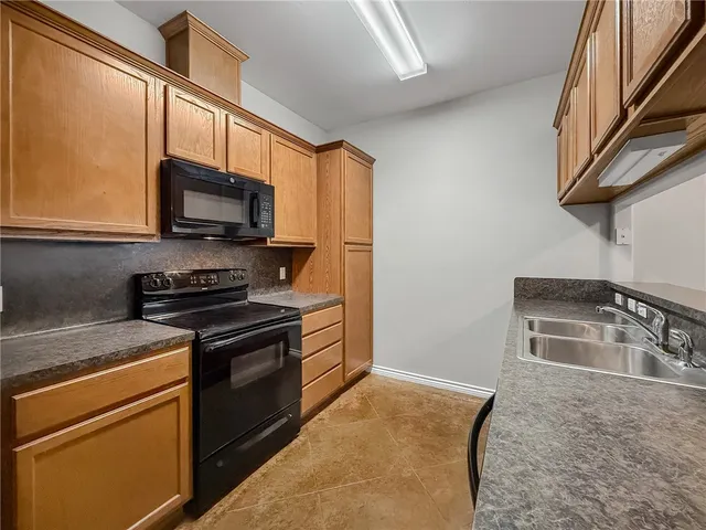 a kitchen with stainless steel appliances granite countertop a stove a sink and a microwave