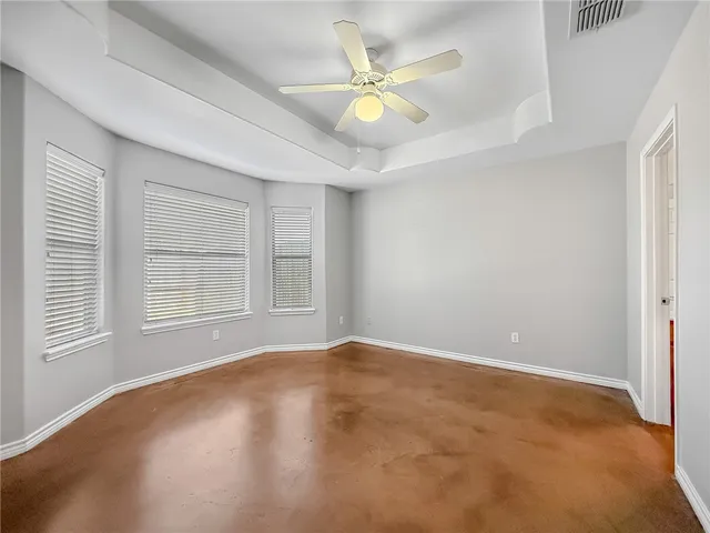 an empty room with windows and fan