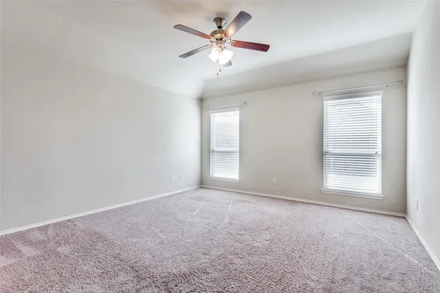 an empty room with windows and fan