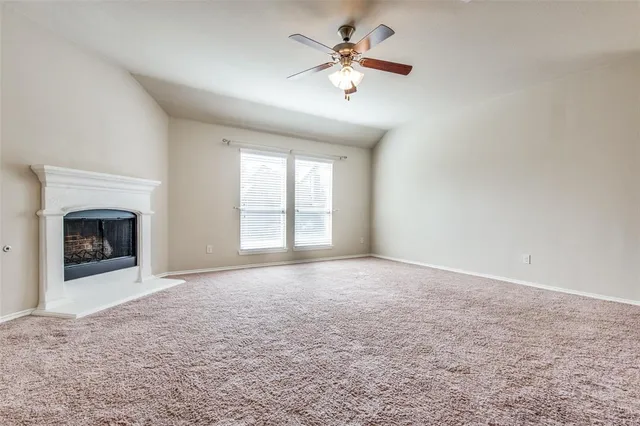 an empty room with windows and fireplace