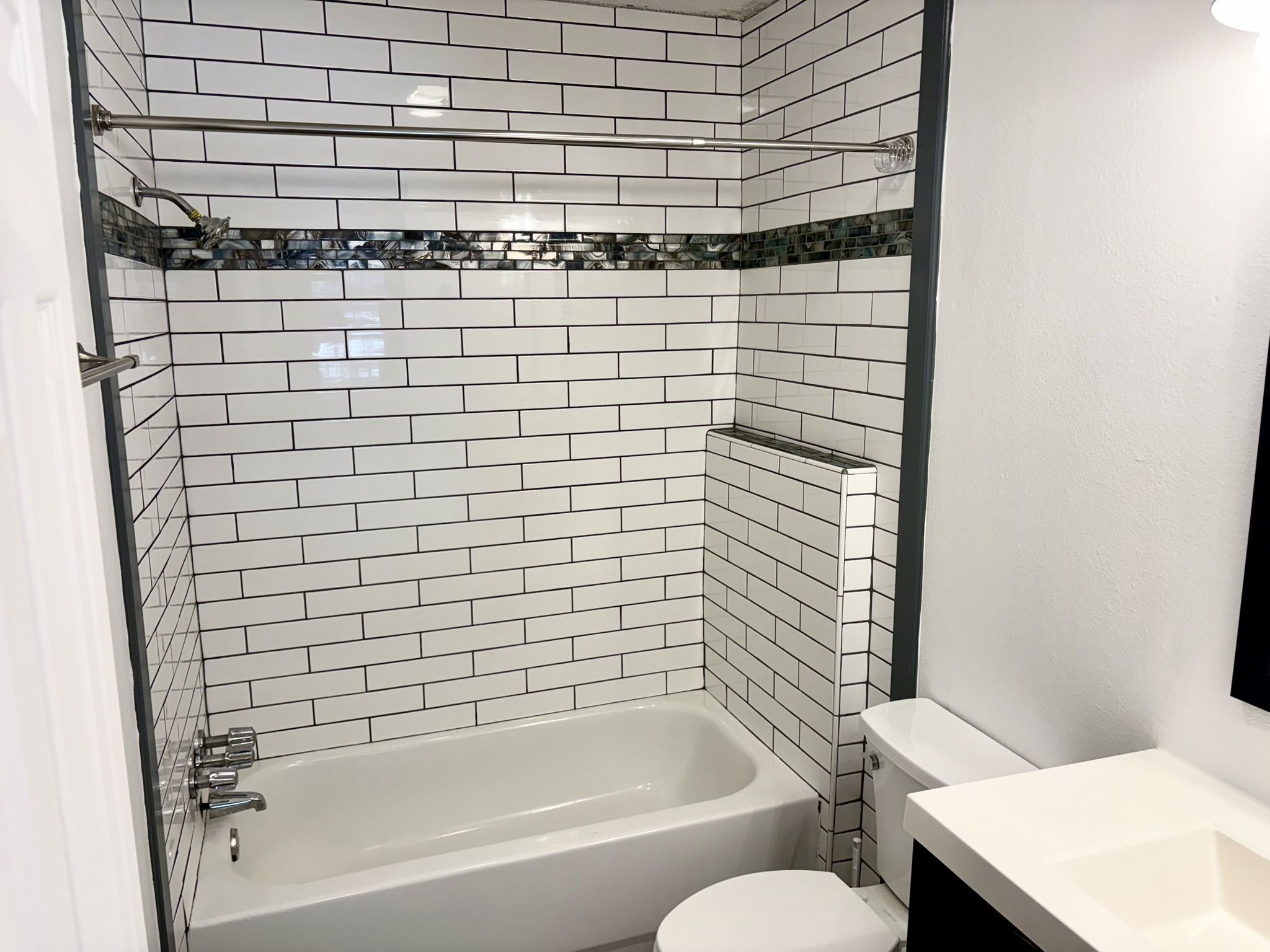 Undisclosed Address Austin, TX 78721 - Photo 12 of 28 Crisp subway tile accents the shower tub combination in this modern bathroom.