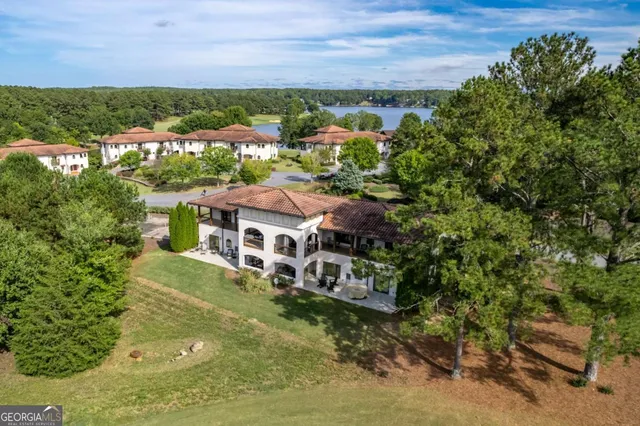 an aerial view of residential houses with outdoor space and trees
