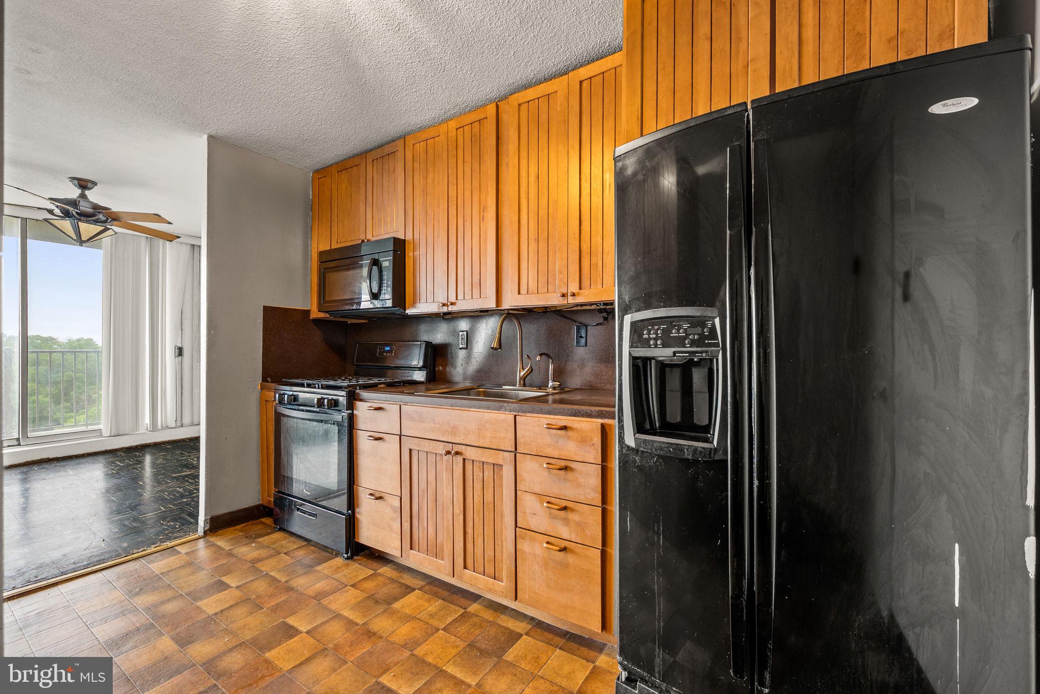 3900 West Ford Road, Unit 11B Philadelphia, PA 19131 - Photo 11 of 24 a kitchen with stainless steel appliances granite countertop a refrigerator and a stove top oven