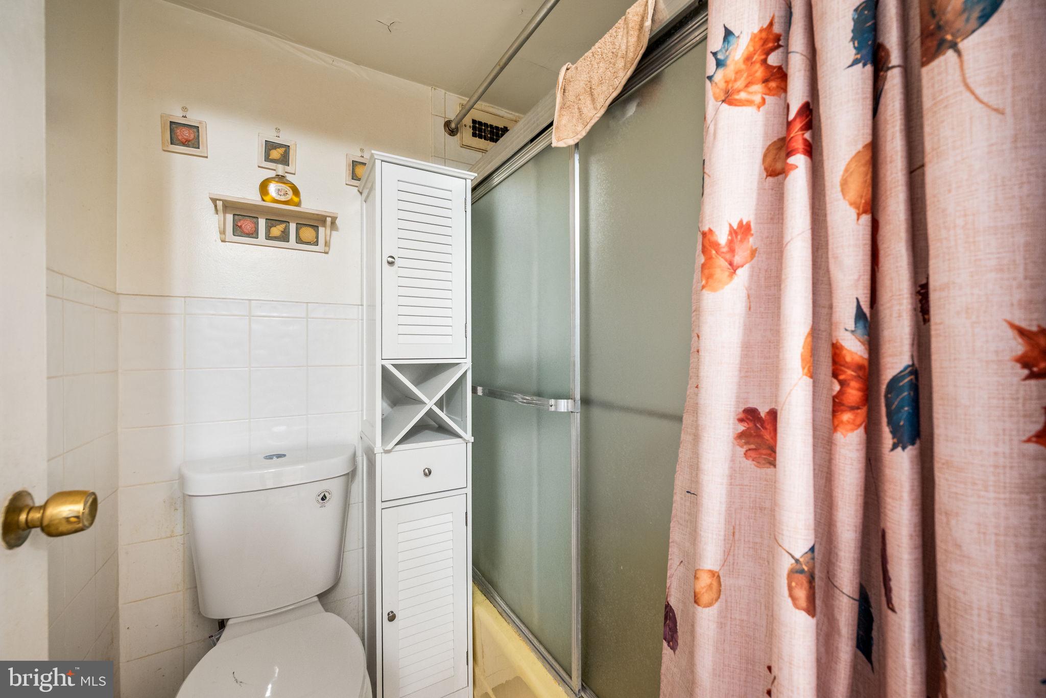3900 West Ford Road, Unit 11B Philadelphia, PA 19131 - Photo 19 of 24 a bathroom with a toilet and a shower curtain