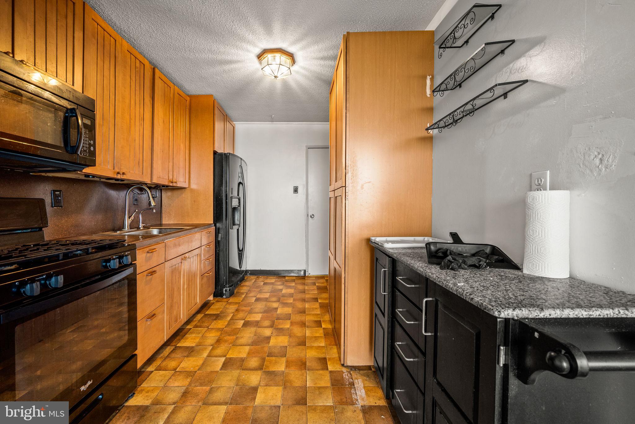 3900 West Ford Road, Unit 11B Philadelphia, PA 19131 - Photo 10 of 24 a kitchen with stainless steel appliances granite countertop a stove and a refrigerator