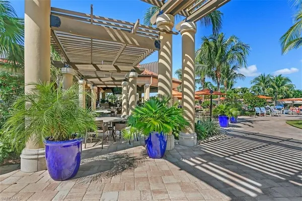 a patio with tables and chairs potted plants