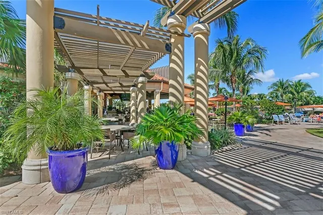 a patio with tables and chairs potted plants